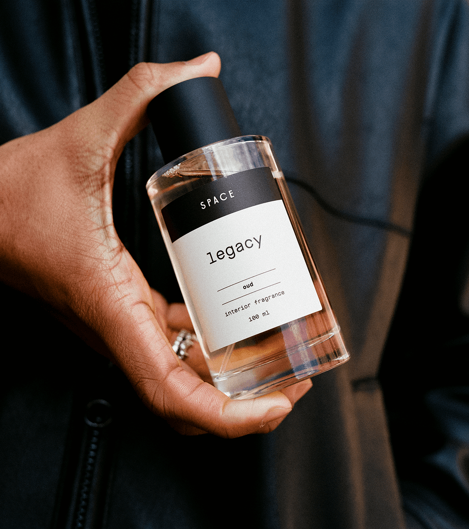 Hand holding Legacy fragrance bottle